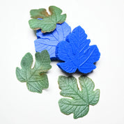 Blue silicone fig leaf veiner molds with realistic green edible paste leaves.