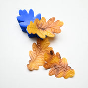 Blue silicone oak leaf mold with realistic yellow and brown pastry leaves showing detailed vein textures.