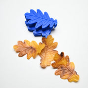 Blue silicone oak leaf mold with detailed veins, shown alongside realistic brown and yellow pastry leaves.