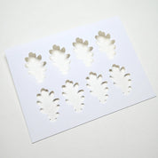 White plastic pastry stencil featuring eight detailed oak leaf cutouts.