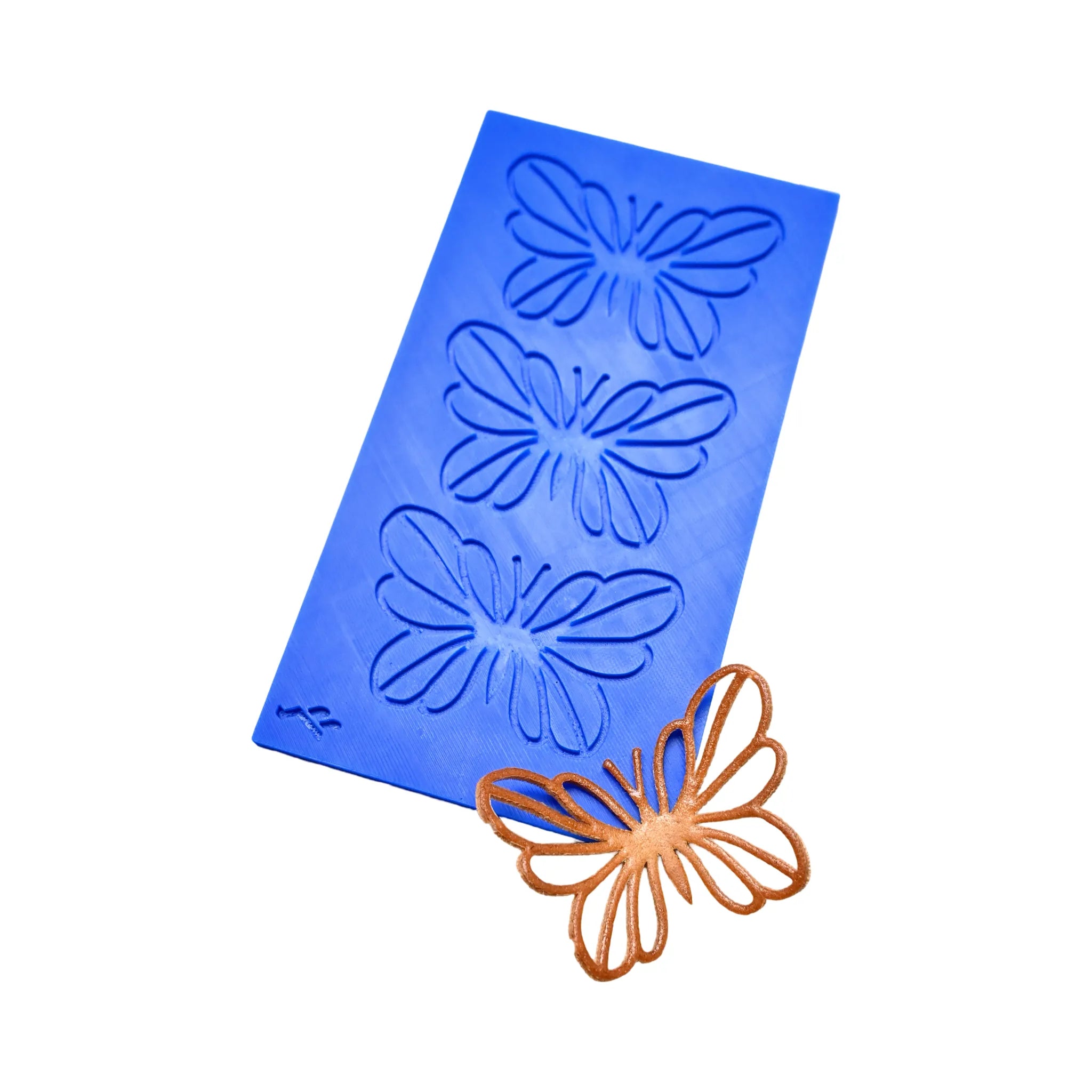 Blue silicone PAPIRYS tuile mat with three butterfly-shaped molds and a finished bronze butterfly tuile.