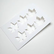 White flexible culinary stencil featuring six detailed vine leaf cutouts.
