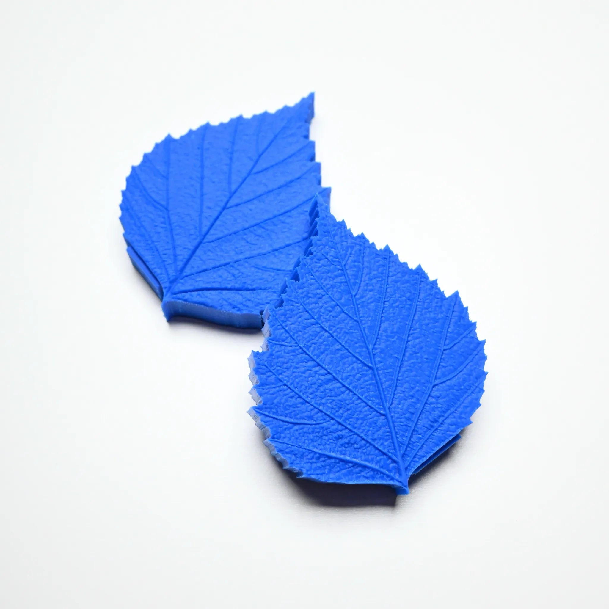 Two blue silicone birch leaf pastry molds showing detailed vein textures on a white background.