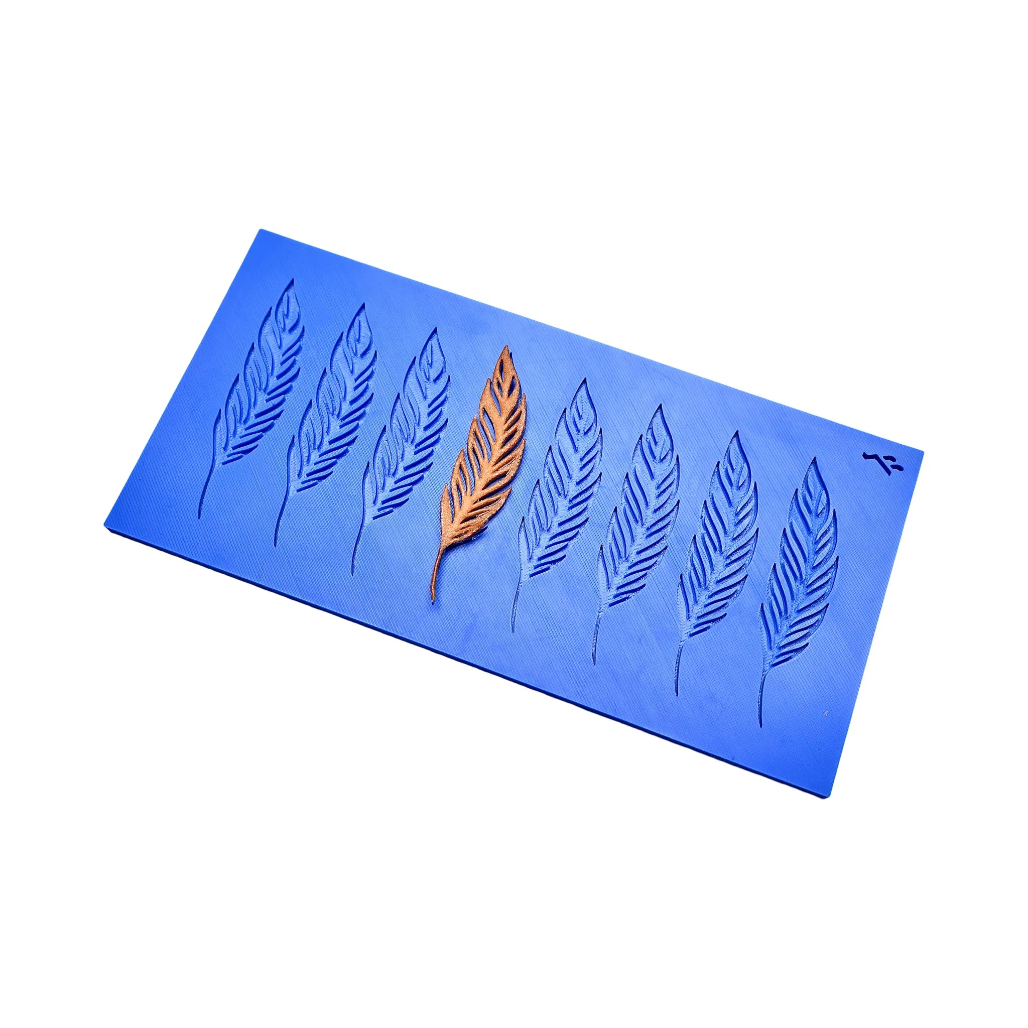 Blue silicone pastry mat with eight feather-shaped tuile molds and one golden feather decoration.
