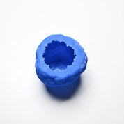 Blue textured silicone truffle mold with a hollow, irregular round shape on a white background.