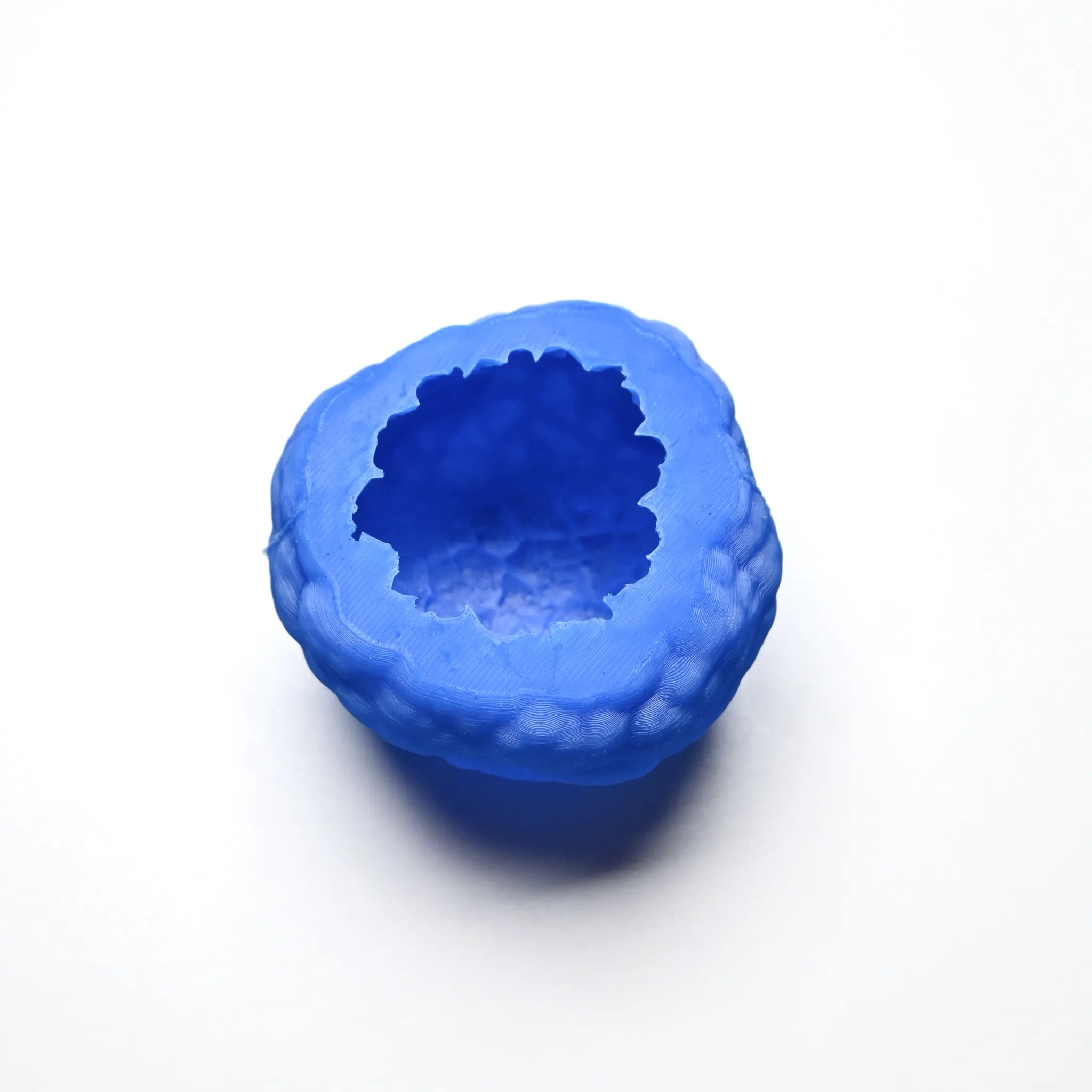 Blue textured silicone truffle mold with a round, irregular shape on a white background.