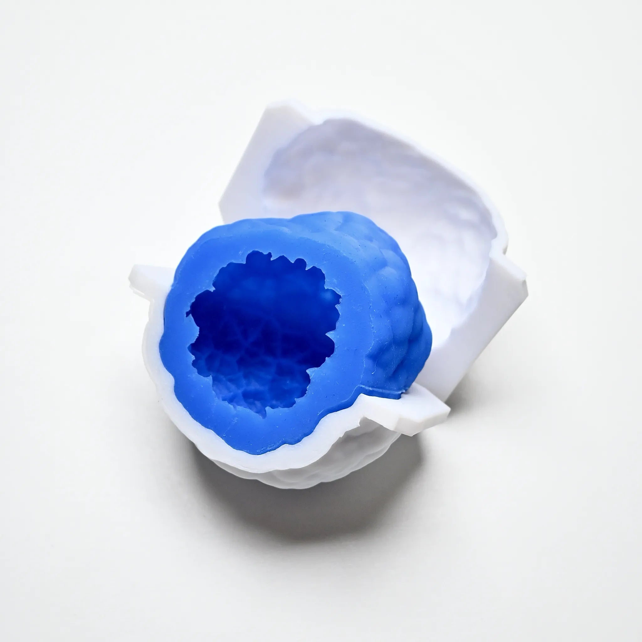 Blue textured silicone truffle mold nested inside a white PLA counter mold.