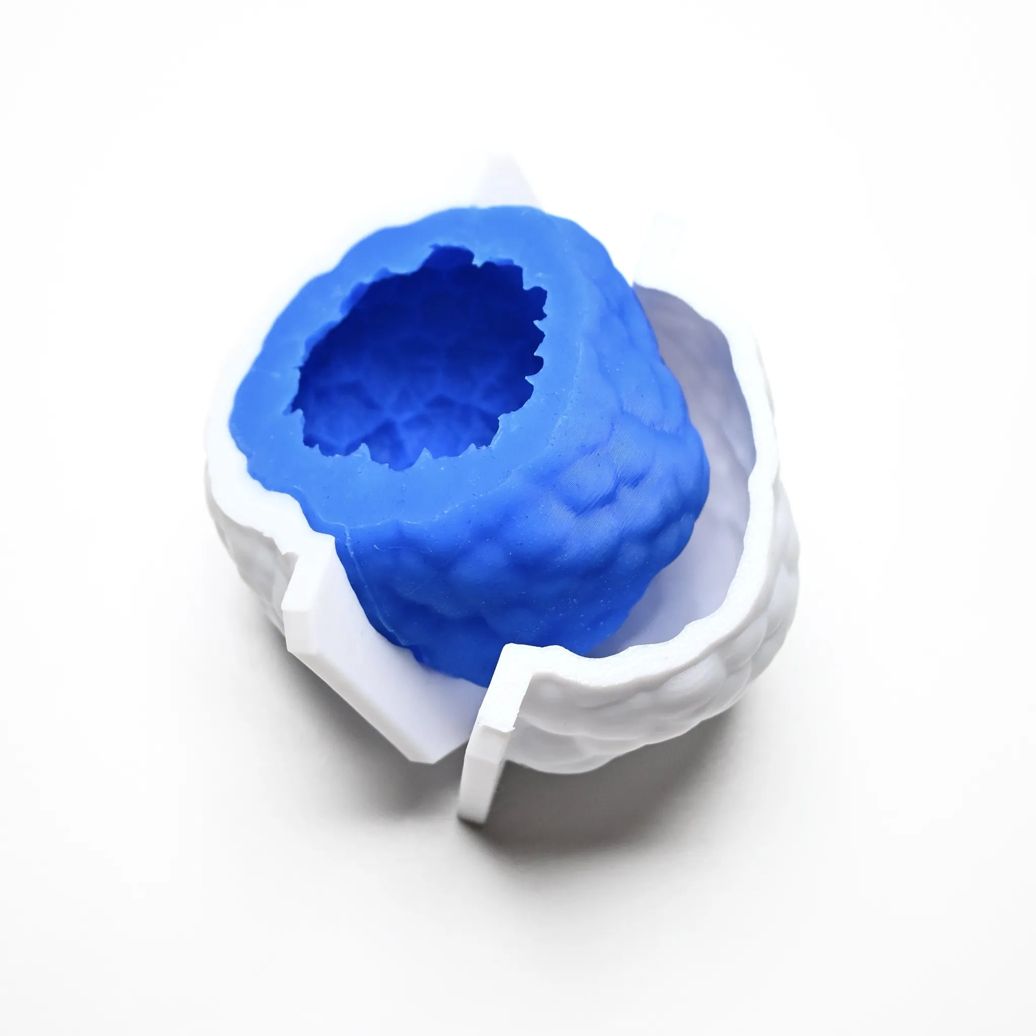 Blue textured silicone truffle mold nested inside a white PLA plastic counter mold.
