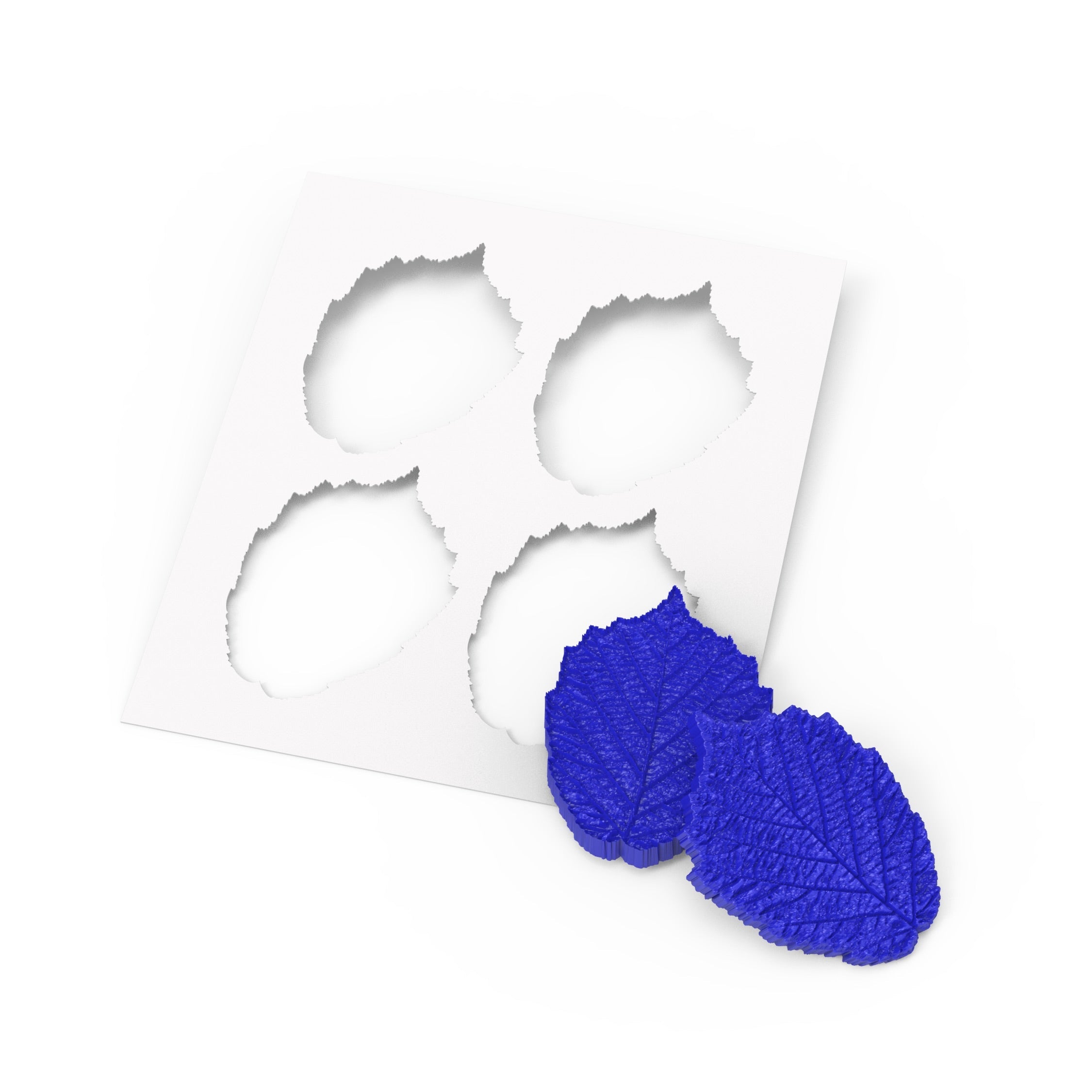 Blue hazelnut leaf silicone pastry molds with a white leaf-shaped stencil template.