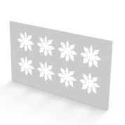 White plastic pastry stencil with eight strawberry calyx leaf cutouts.