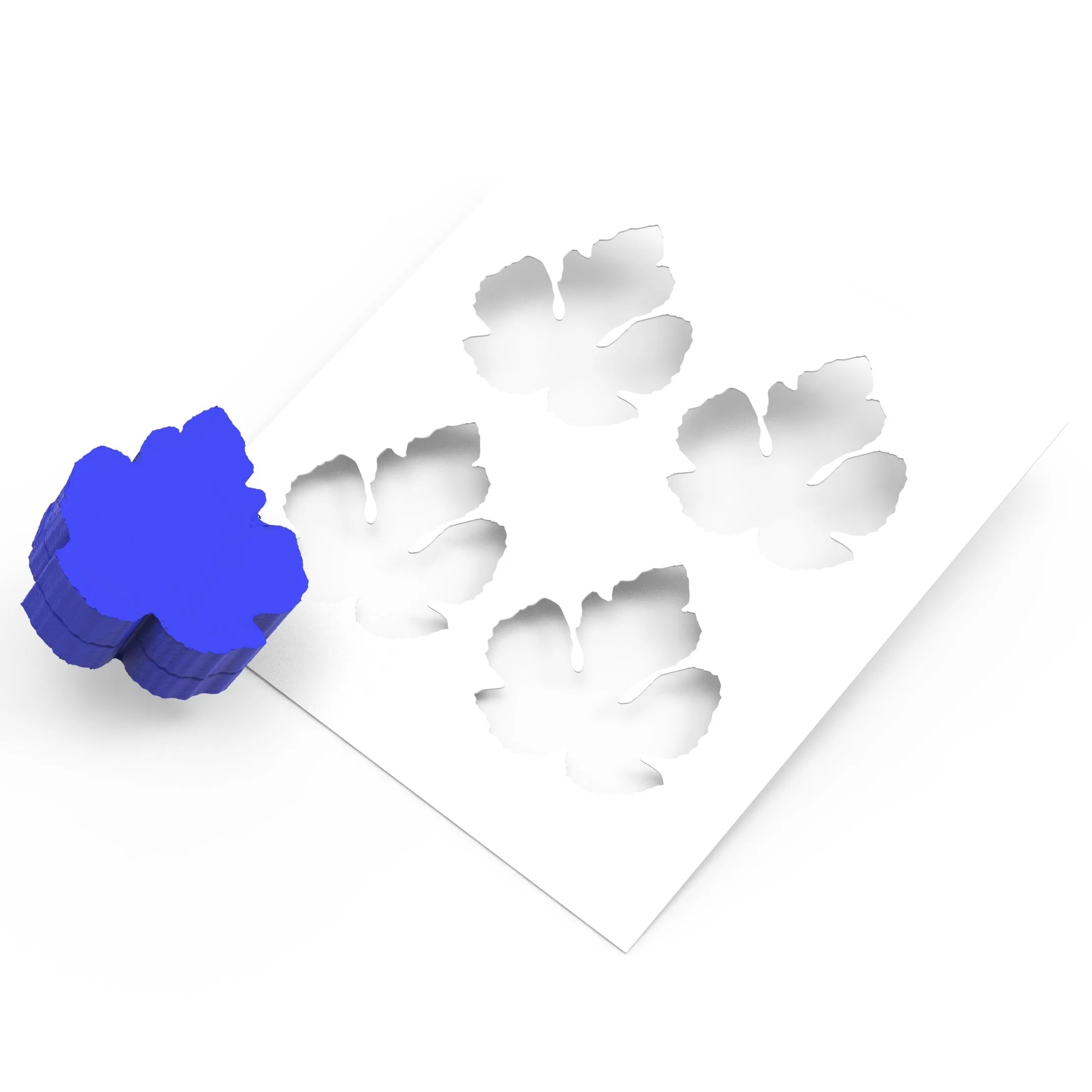 Blue fig leaf silicone mold press next to a white stencil with four leaf-shaped cutouts.