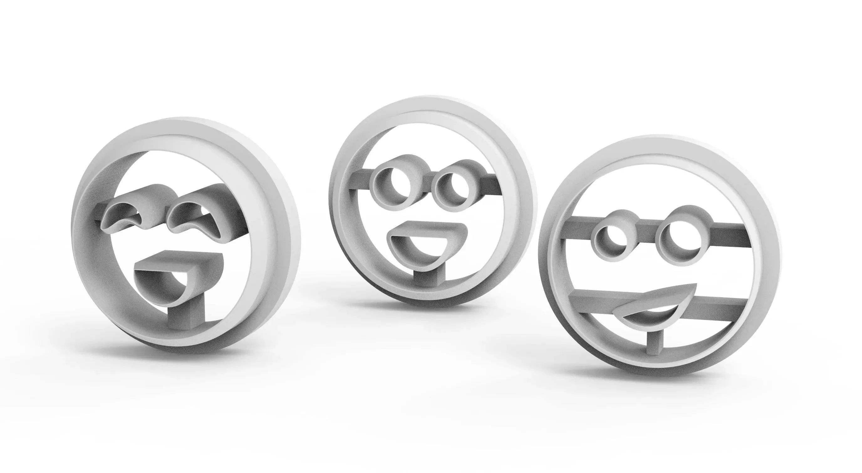 Three white plastic smiley face cookie cutters with glasses and happy expressions.