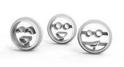 Three white plastic smiley face cookie cutters with glasses and happy expressions.