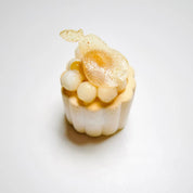 Mini Charlotte dessert with fluted sides, topped with pear-shaped sugar art.
